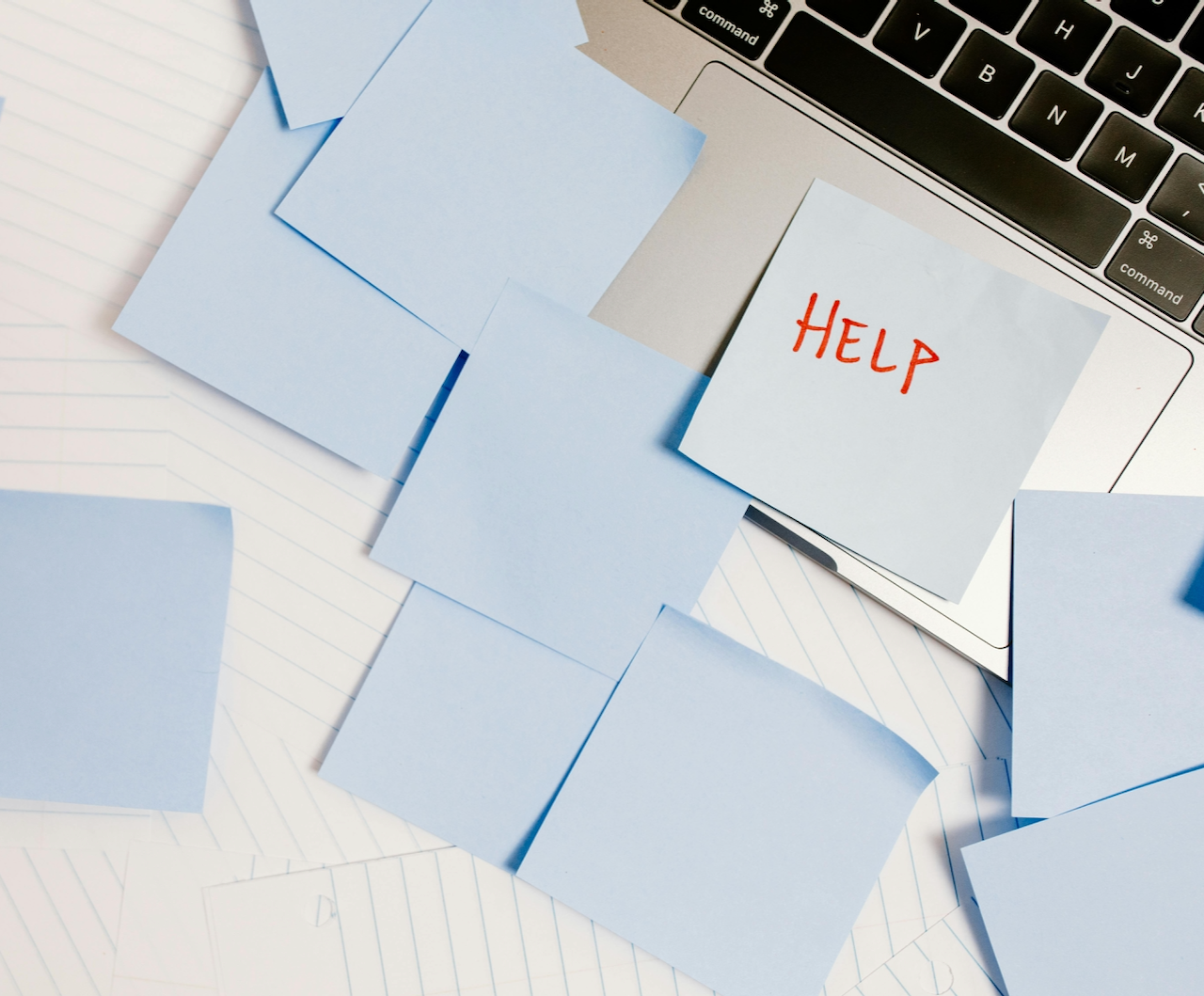 Photo of laptop with a post-it note saying HELP