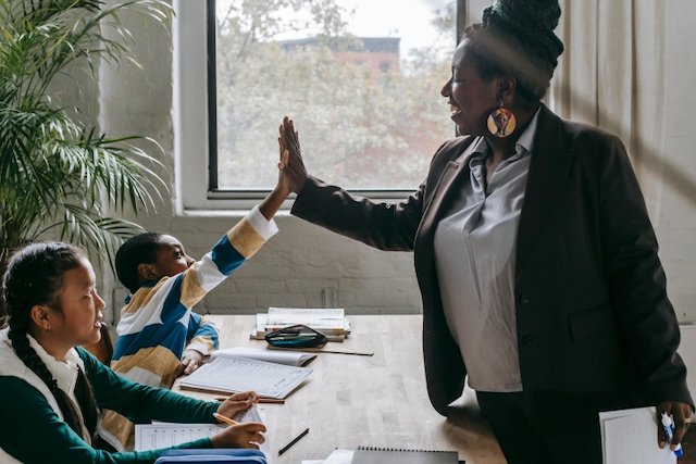 Happy teacher high-fiving student